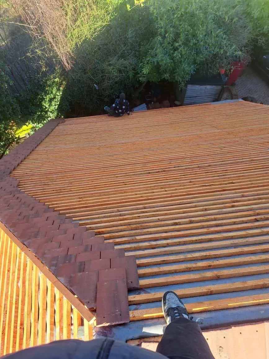 New battens across a roof slope beside the old tiles