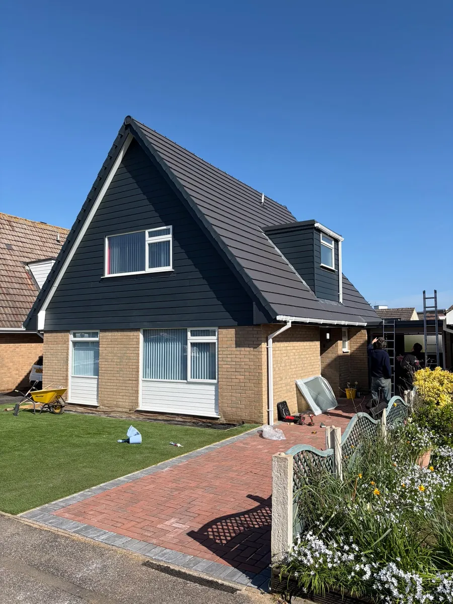 Chalet bungalow finished with new grey tiles and dark cladding