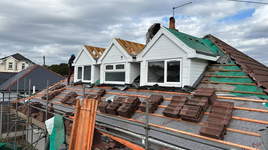 Tiles loaded out on a roof with three dormers