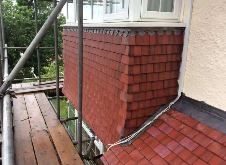 Red plain tiles on a bay roof from the scaffold
