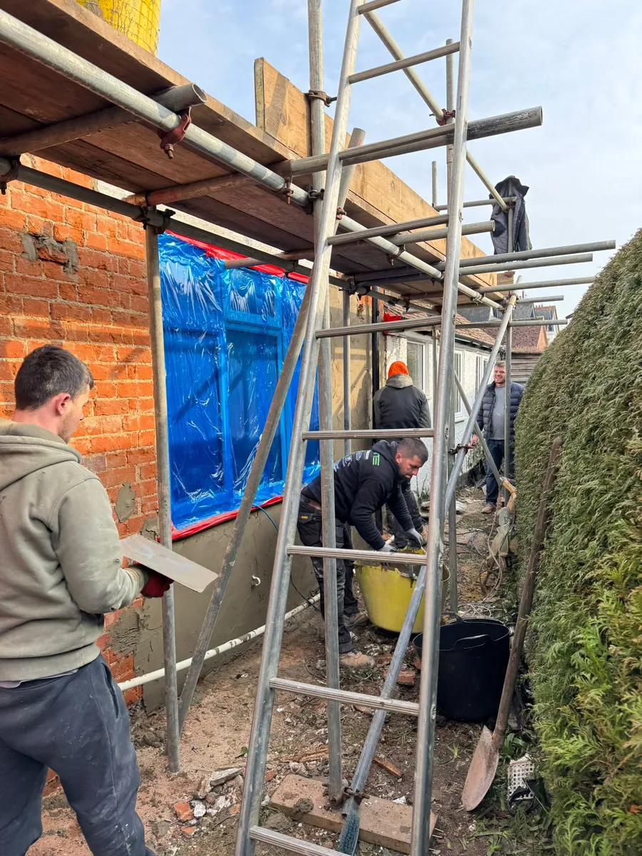 Team rendering a wall from the scaffold