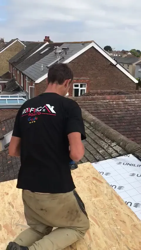 Roofer laying boards and membrane