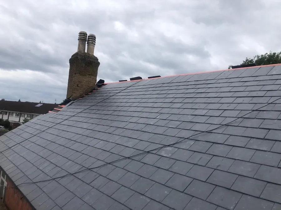 Finished slate roof beside a chimney stack