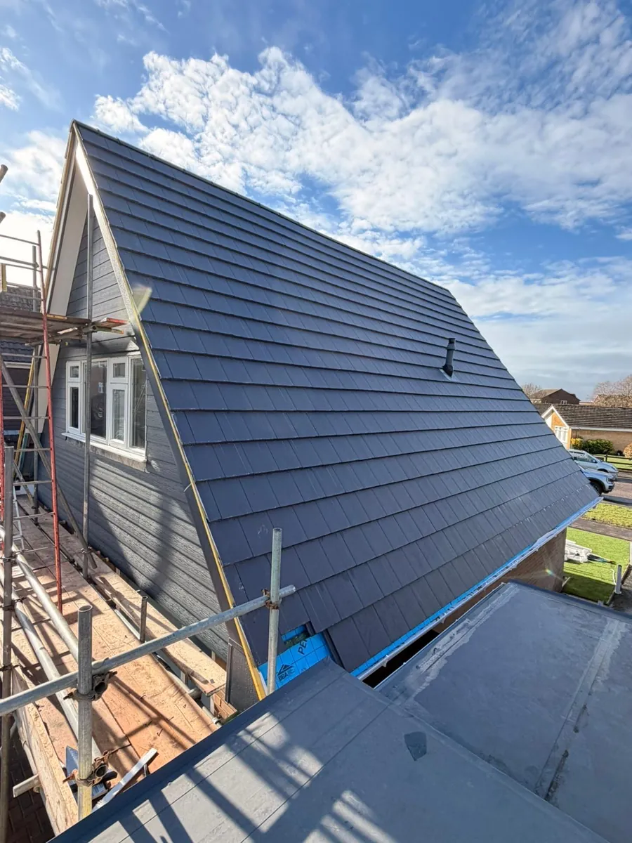 Slate roof on a gable with a dormer and flat roof below