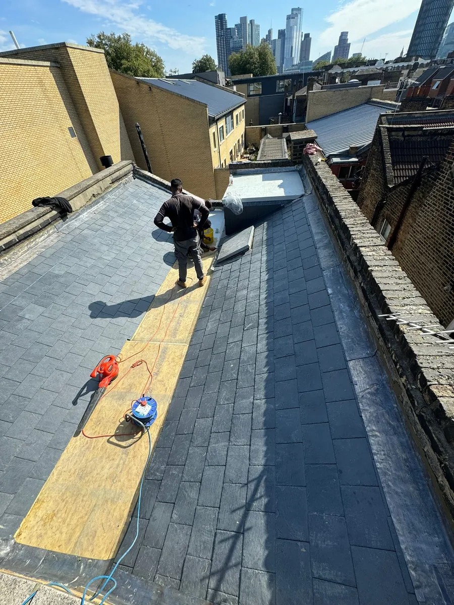 Slates going on a London terrace roof with the city skyline behind