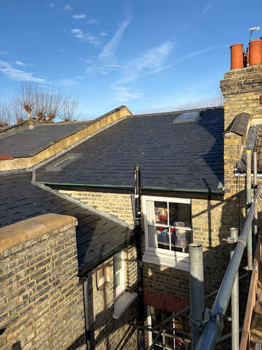 Slate roof on a yellow brick terrace between chimney pots