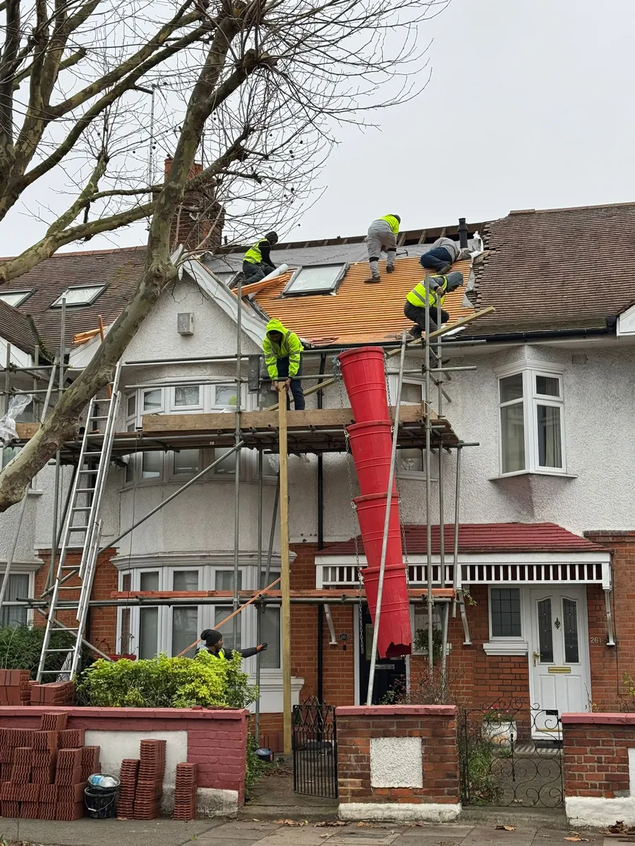 Team re-roofing a terraced house with a rubbish chute