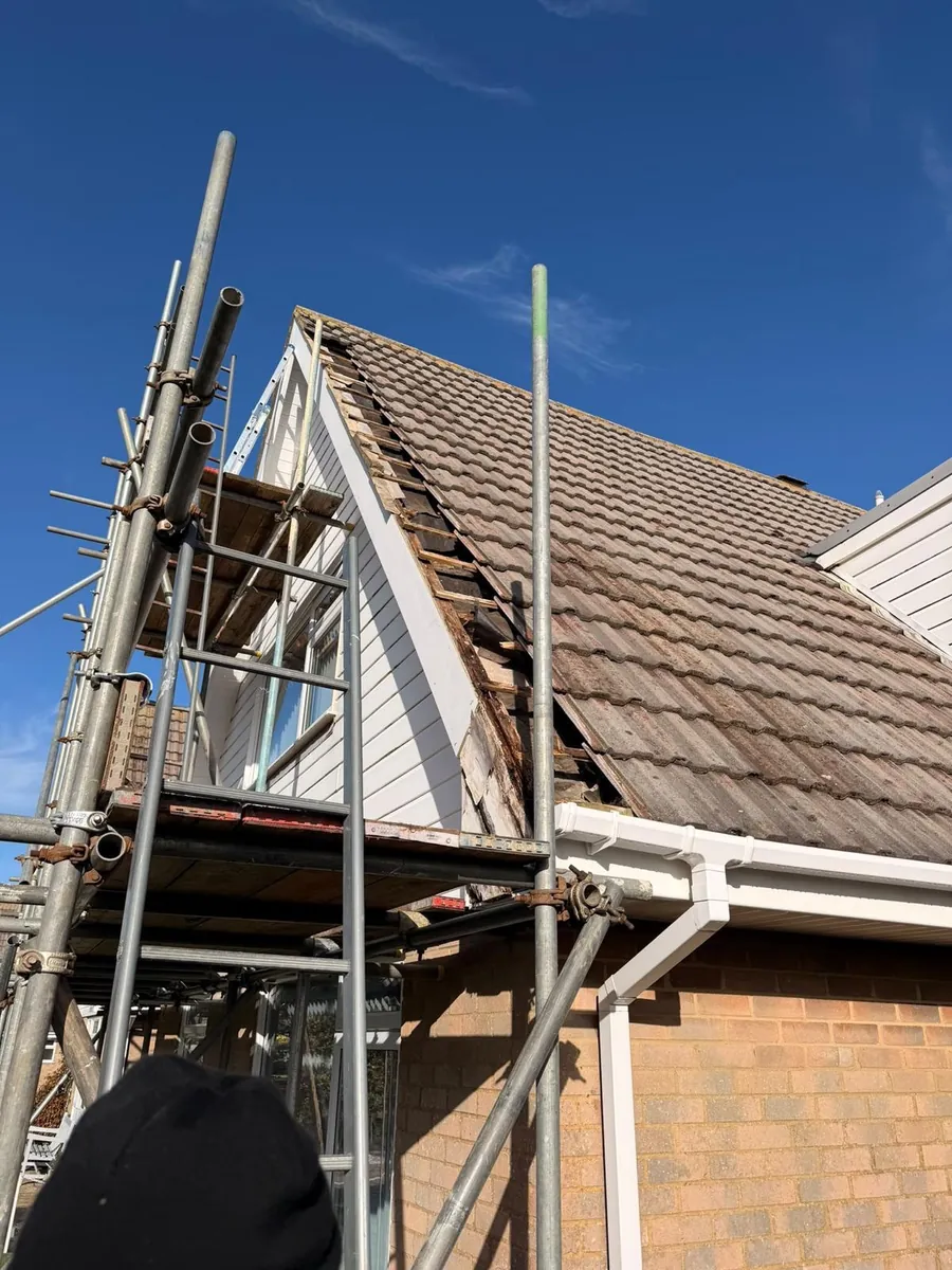 Old tiles being stripped at a gable end