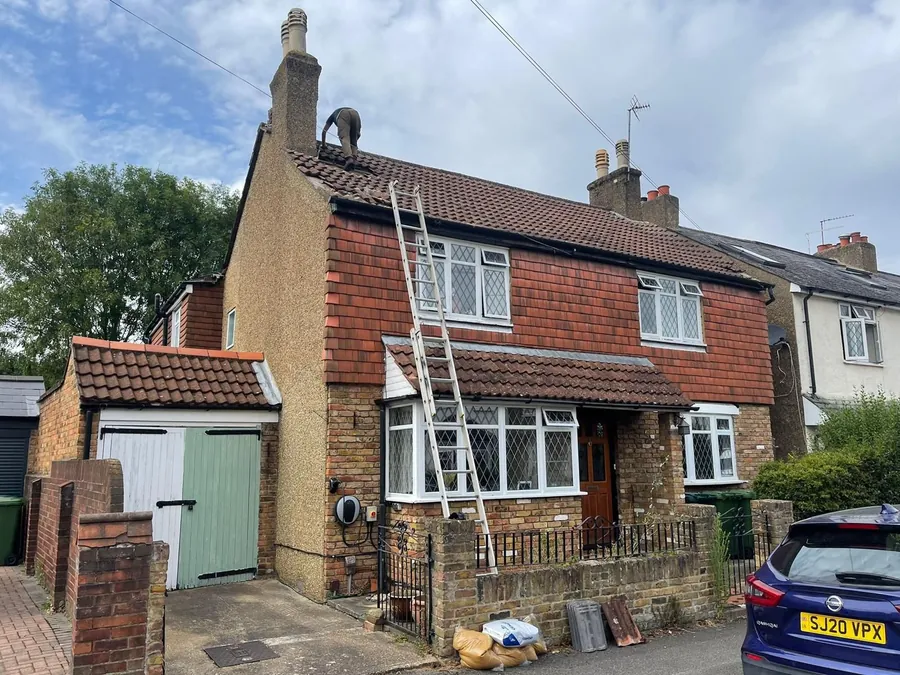 Tiled roof on a detached house with ladders up for the job
