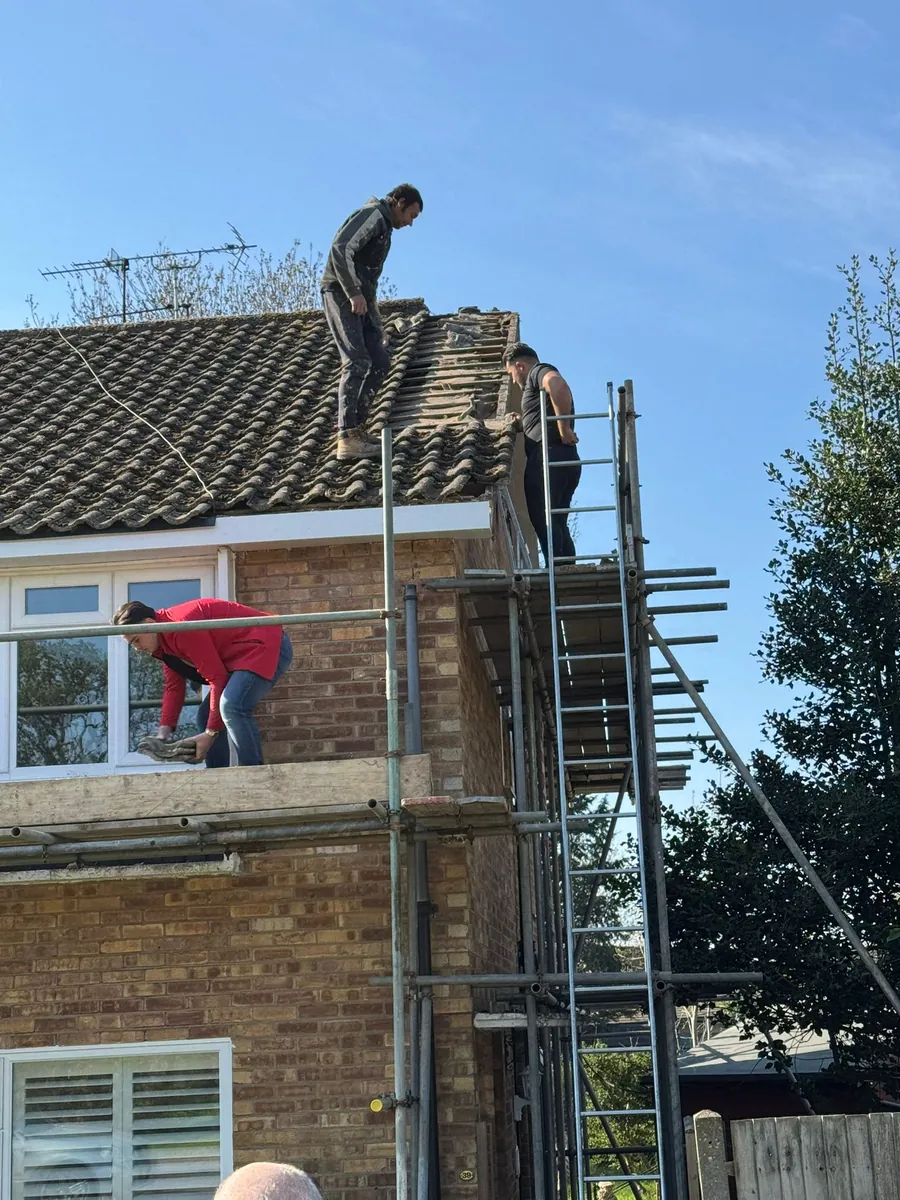 Roofer working on a tiled roof from the scaffold