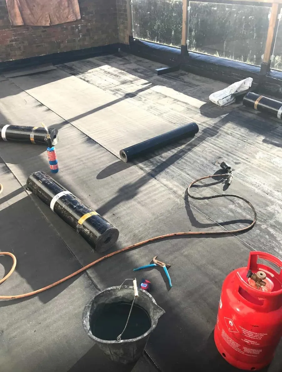 Torch-on felt rolls on a flat roof during the job