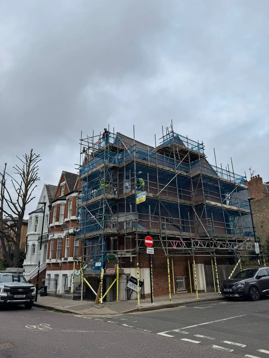 Victorian corner house wrapped in scaffold for roof work